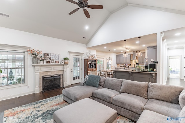 living room with ceiling fan, visible vents, a fireplace, dark wood finished floors, and a wealth of natural light