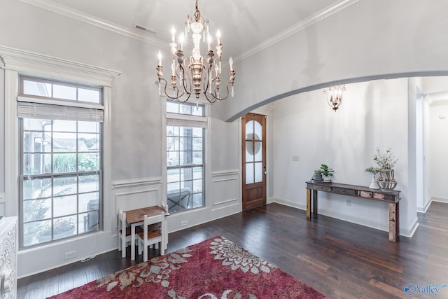 entryway featuring crown molding, a notable chandelier, arched walkways, dark wood finished floors, and visible vents