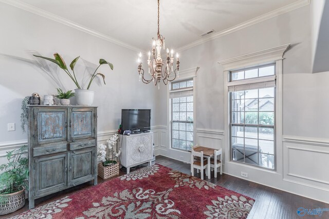 interior space featuring crown molding, an inviting chandelier, a wainscoted wall, and hardwood / wood-style floors