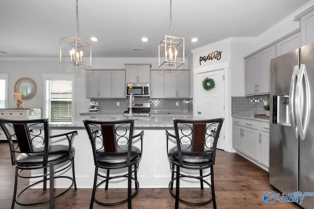 kitchen featuring appliances with stainless steel finishes, pendant lighting, decorative backsplash, and dark hardwood / wood-style flooring