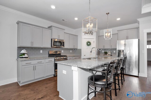 kitchen with a kitchen bar, sink, backsplash, appliances with stainless steel finishes, and dark hardwood / wood-style floors