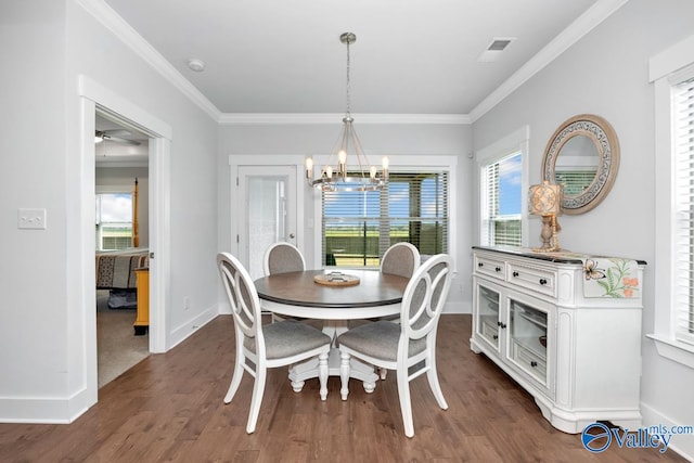 dining space featuring ceiling fan with notable chandelier, crown molding, and dark hardwood / wood-style floors