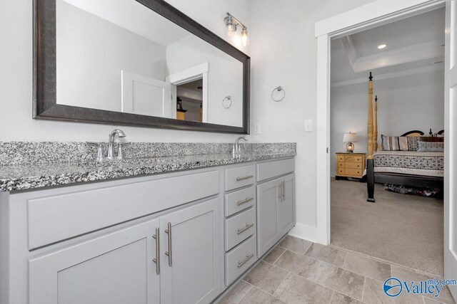 bathroom with tile patterned floors, vanity, and a tray ceiling