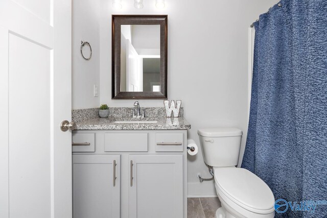 bathroom featuring toilet, vanity, and tile patterned floors