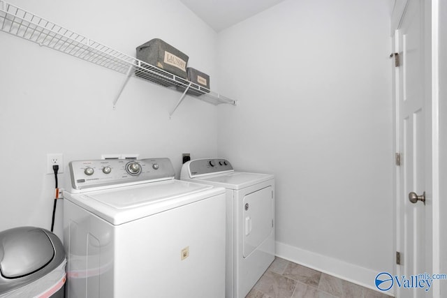 laundry area with independent washer and dryer and light tile patterned flooring