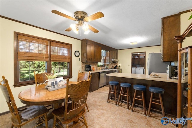 19660 Cox Rd, Athens, AL 35611 - dining area with crown molding, washing machine and clothes dryer, a ceiling fan, and light tile patterned floors