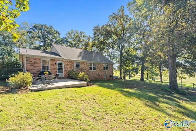 19660 Cox Rd, Athens, AL 35611 - rear view of house featuring brick siding, fence, a patio area, and a lawn