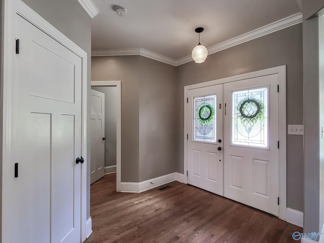 foyer entrance with ornamental molding and dark hardwood / wood-style floors