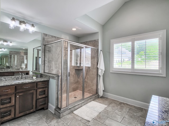 bathroom with vanity, vaulted ceiling, and a shower with shower door