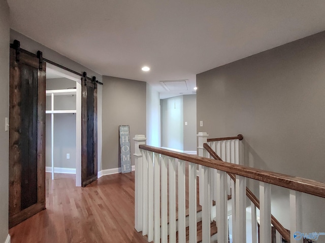 hall featuring a barn door and light hardwood / wood-style flooring