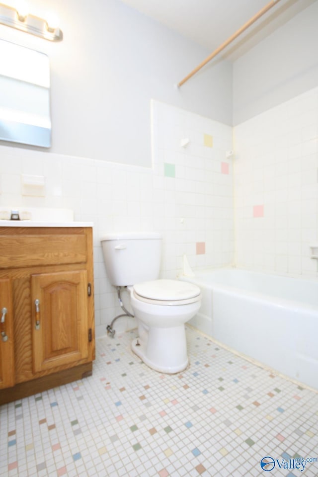 full bathroom featuring tile patterned floors, vanity, tile walls, and toilet