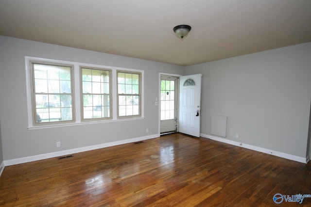 empty room with a healthy amount of sunlight and dark hardwood / wood-style floors