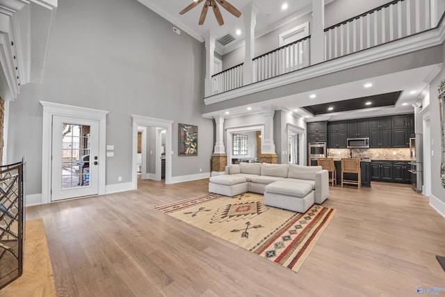 2603 Whitesburg Dr, Huntsville, AL 35801 - living area featuring a ceiling fan, light wood-style floors, a high ceiling, ornamental molding, and decorative columns