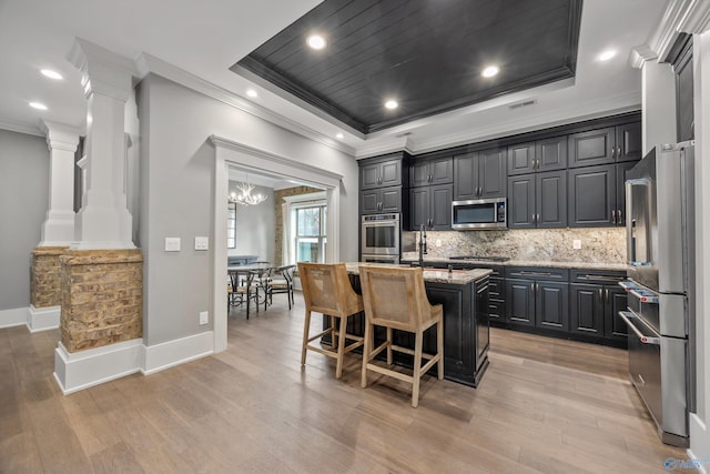 2603 Whitesburg Dr, Huntsville, AL 35801 - kitchen with stainless steel appliances, a kitchen island with sink, a raised ceiling, tasteful backsplash, and ornamental molding