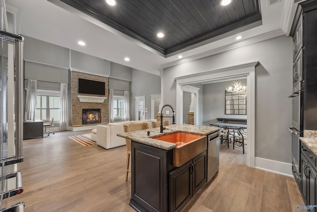 2603 Whitesburg Dr, Huntsville, AL 35801 - kitchen featuring ornamental molding, a sink, light wood-style floors, a fireplace, and appliances with stainless steel finishes