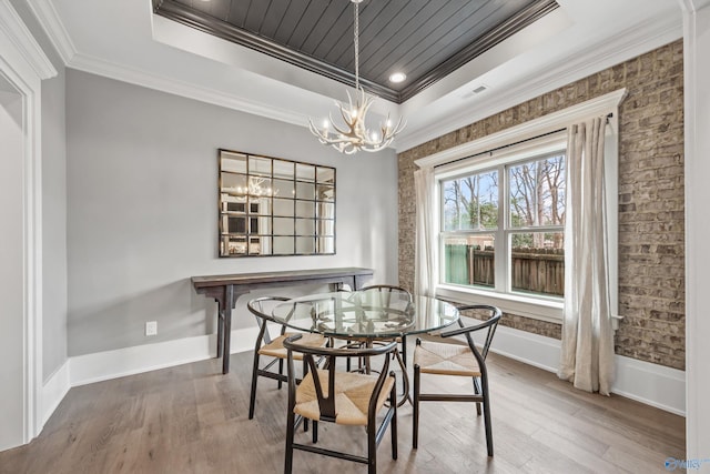 2603 Whitesburg Dr, Huntsville, AL 35801 - dining area featuring a tray ceiling, wood finished floors, a notable chandelier, and ornamental molding