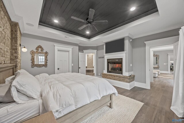 2603 Whitesburg Dr, Huntsville, AL 35801 - bedroom featuring a raised ceiling, wood finished floors, crown molding, baseboards, and a lit fireplace