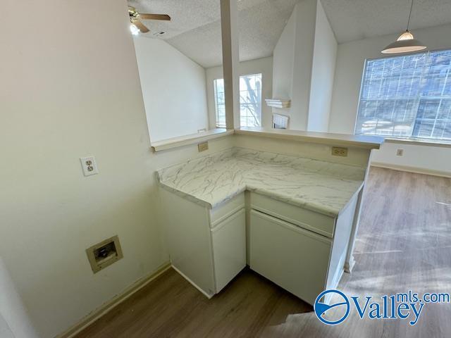 kitchen with kitchen peninsula, ceiling fan, plenty of natural light, and a textured ceiling