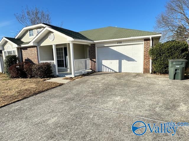 ranch-style home with covered porch and a garage