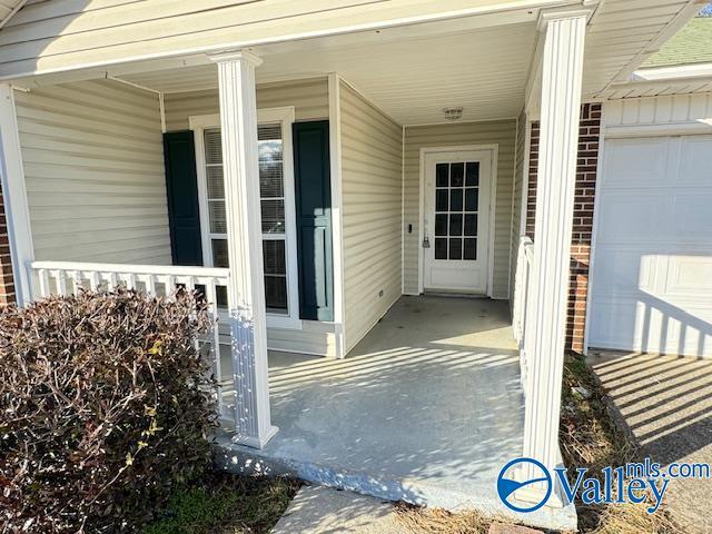 view of exterior entry with covered porch and a garage