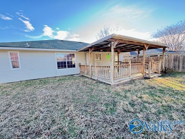 back of property featuring a deck and a yard