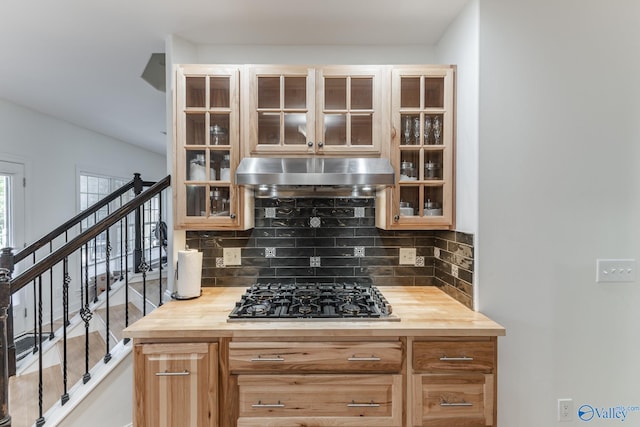 kitchen with tasteful backsplash, black gas stovetop, and wood counters