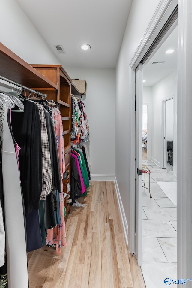 spacious closet with light hardwood / wood-style floors