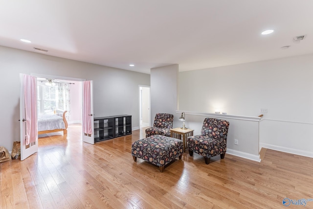 sitting room with light wood-type flooring and ceiling fan