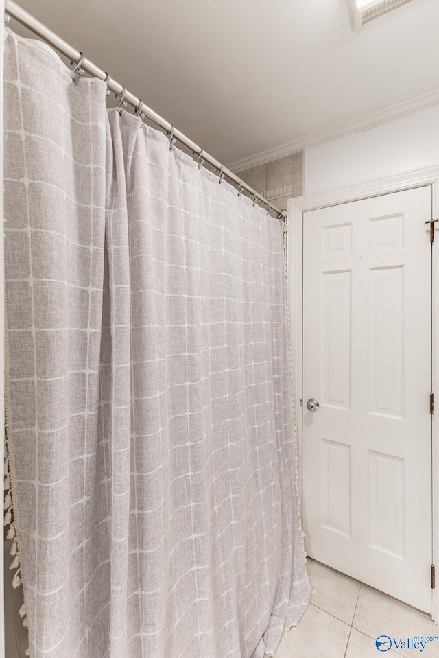 full bath featuring a shower with curtain, tile patterned flooring, visible vents, and ornamental molding