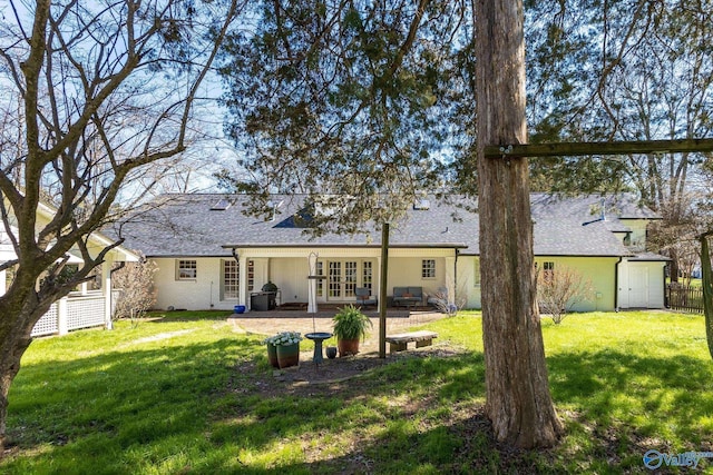 rear view of house with a yard, a patio, french doors, and fence