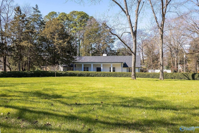 view of front of property featuring a front yard and a chimney