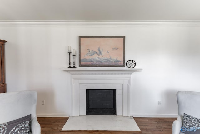 living area with a fireplace, baseboards, and wood finished floors