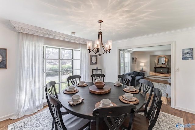 dining space featuring crown molding, baseboards, and wood finished floors