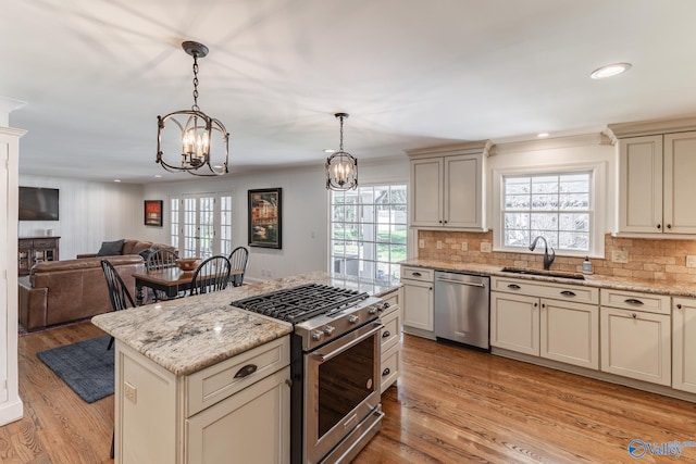 kitchen with plenty of natural light, cream cabinetry, stainless steel appliances, and a sink