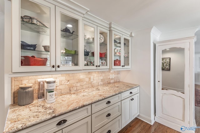 bar with backsplash, dark wood finished floors, and baseboards