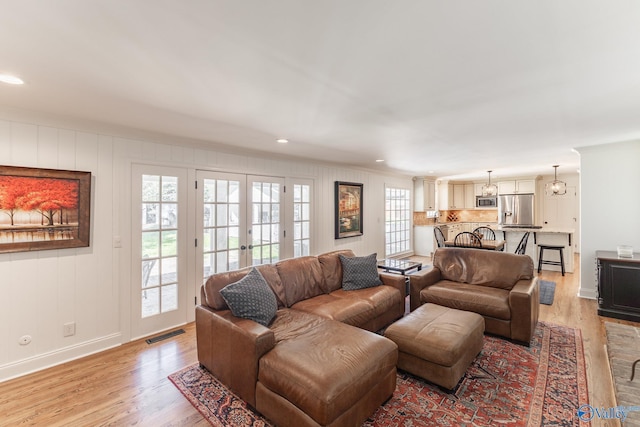 living room featuring recessed lighting, visible vents, baseboards, french doors, and light wood-type flooring