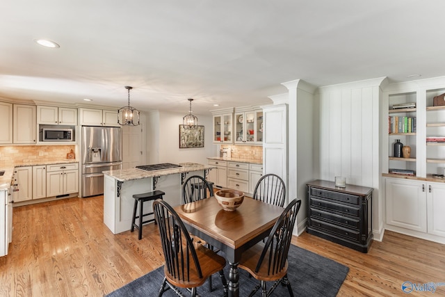 dining space featuring light wood finished floors, an inviting chandelier, and recessed lighting