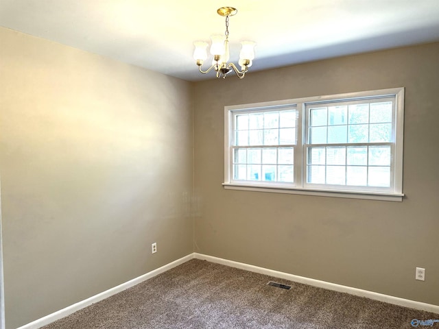 carpeted empty room featuring visible vents, baseboards, and an inviting chandelier