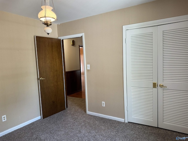 unfurnished bedroom with a closet, carpet flooring, and baseboards