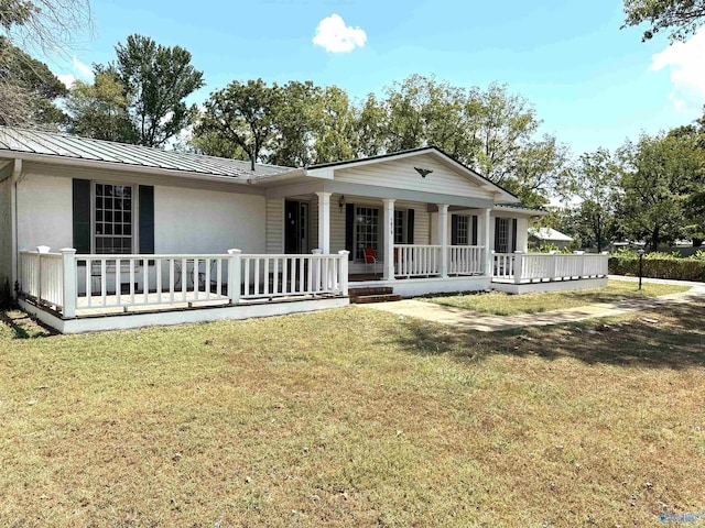 ranch-style home with a standing seam roof, metal roof, covered porch, and a front yard