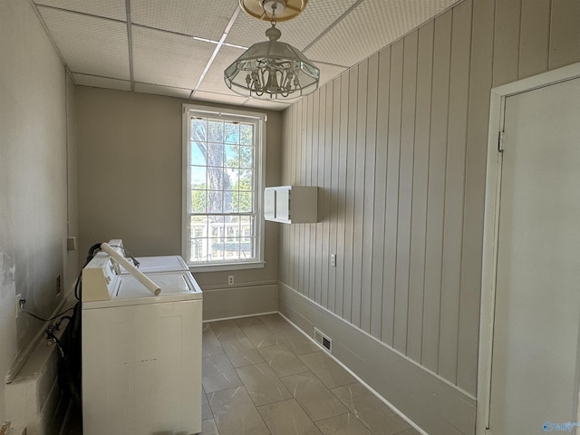 laundry area featuring laundry area, wooden walls, visible vents, and washer and dryer