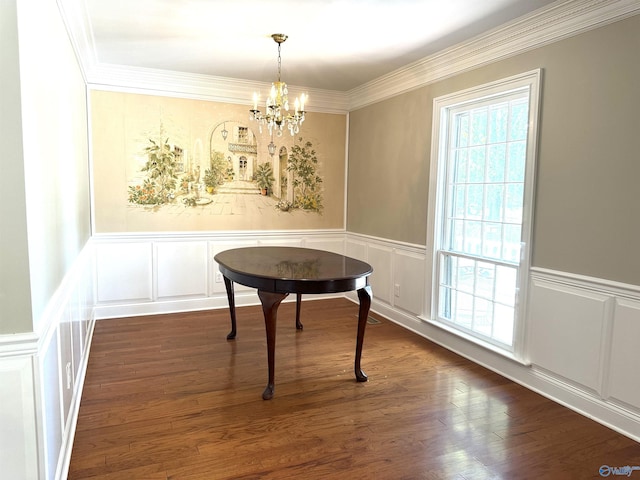 dining space with dark wood-type flooring, a chandelier, ornamental molding, and a decorative wall