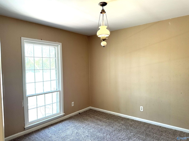carpeted spare room featuring a wealth of natural light and baseboards