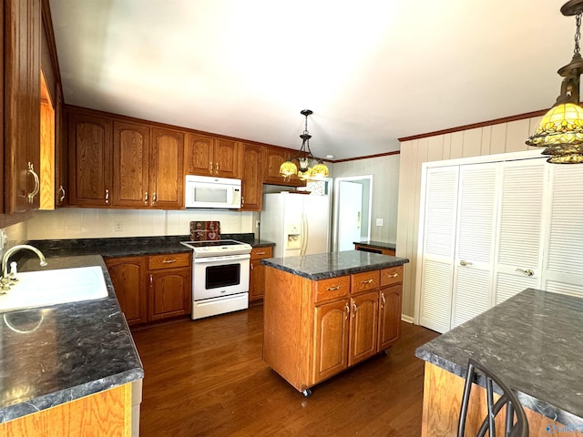 kitchen featuring white appliances, dark wood-type flooring, a sink, and a center island