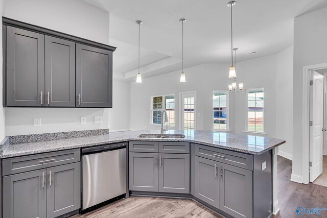 kitchen featuring sink, light stone counters, hanging light fixtures, light wood-type flooring, and dishwasher