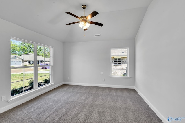 carpeted spare room featuring visible vents, baseboards, lofted ceiling, and a ceiling fan