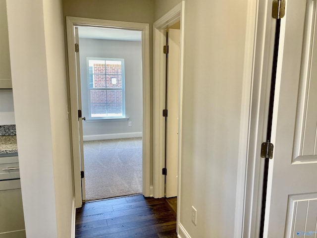 hallway with dark wood-style floors and baseboards