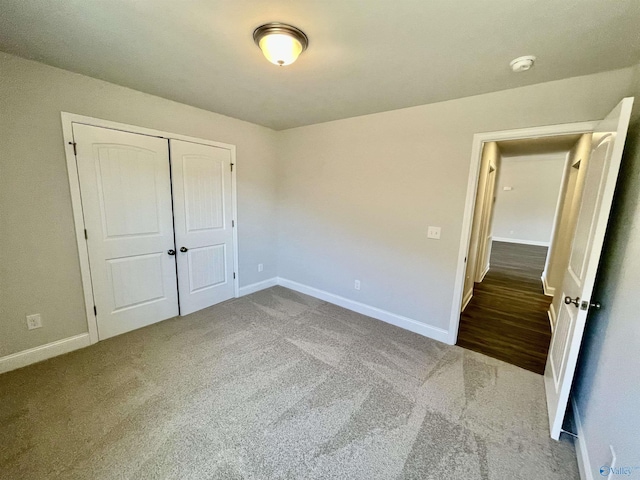 unfurnished bedroom with a closet, baseboards, and carpet floors