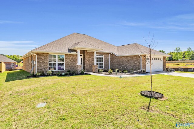 view of front of house with brick siding, an attached garage, driveway, and a front yard