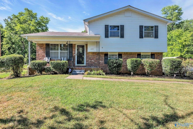 split level home featuring brick siding, a front lawn, and a porch